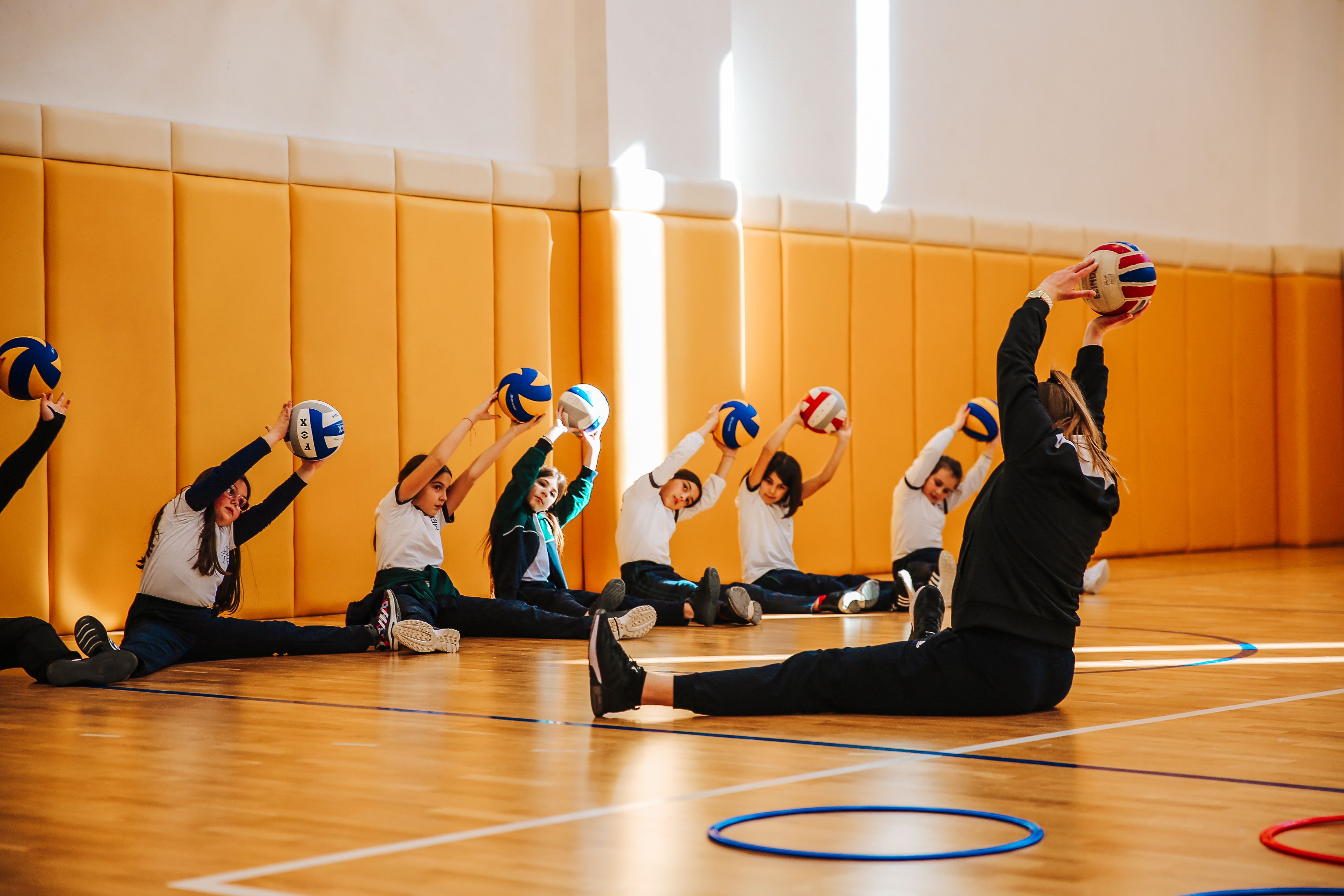 Female PE teacher delivering primary school sport session in sports hall